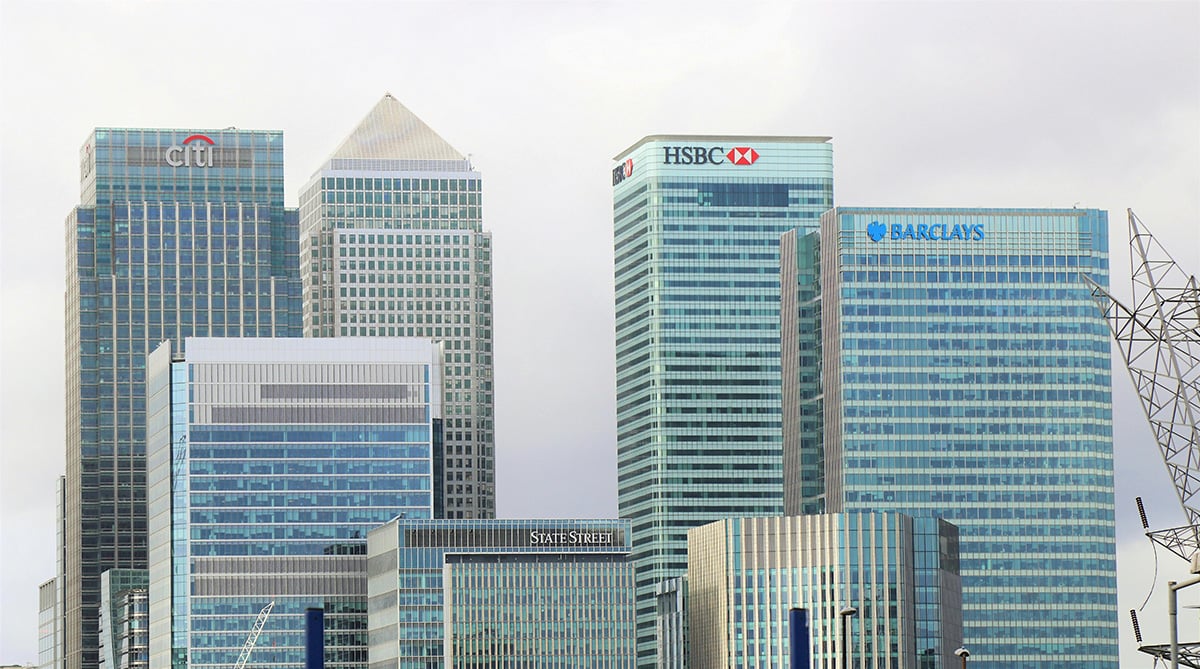 A city skyline with glass buildings featuring logos from Citi Group, HSBC, Barclays, State Street and other big banks