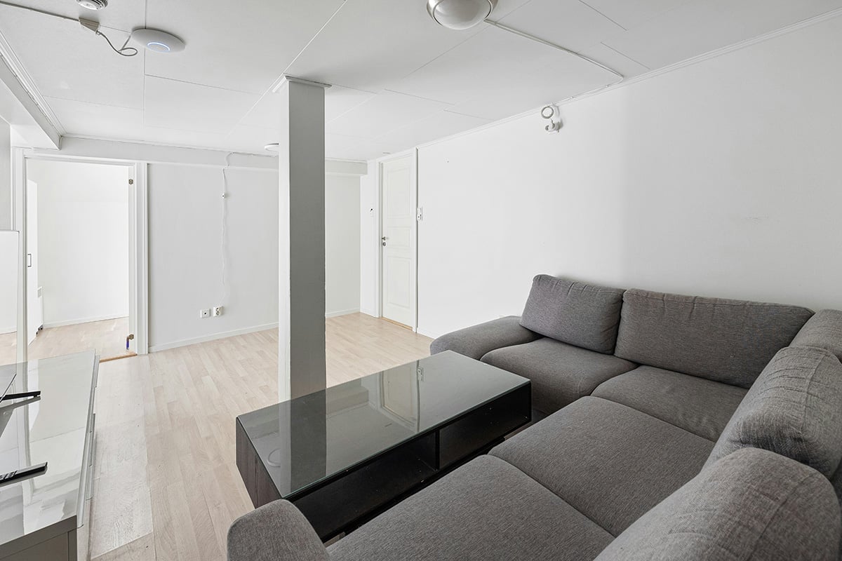 An apartment with no windows and a column in the middle of the living room