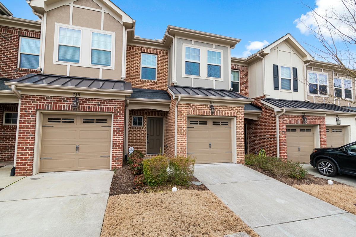The exterior of a row of brick townhomes in a suburban neighborhood 