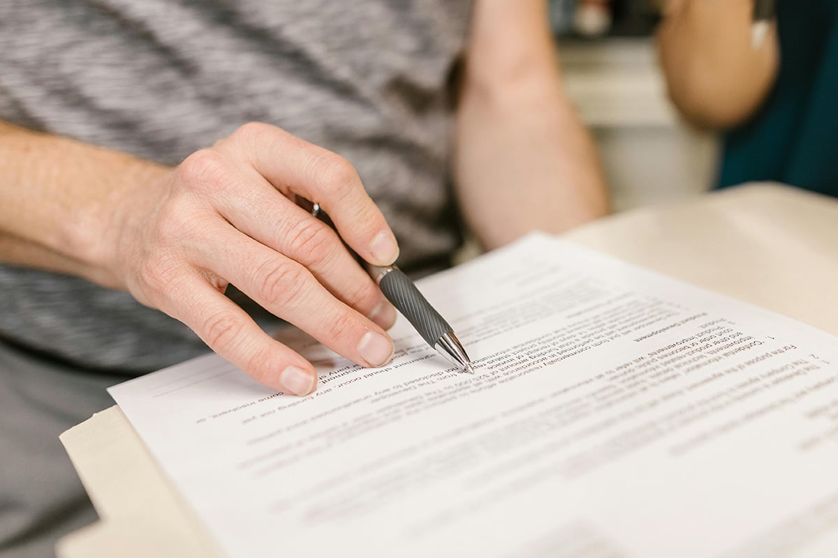 A person going over a lease agreement with a pen